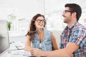 Happy coworkers working together with computer