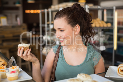 Pretty brunette holding a cupcake