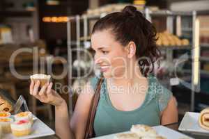 Pretty brunette holding a cupcake