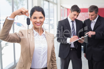 Smiling saleswoman holding a customer car key