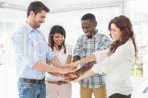 Smiling coworkers joining hands in a circle