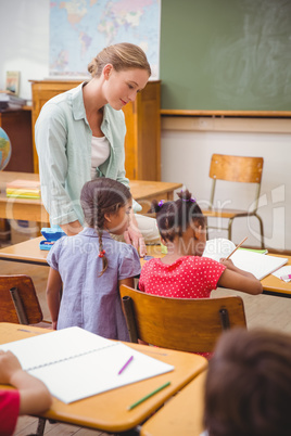 Teacher and pupils working at desk together