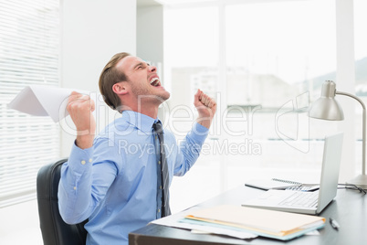 Businessman holding document cheering