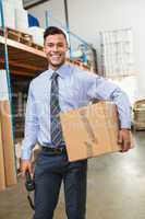 Warehouse manager holding cardboard box and scanner