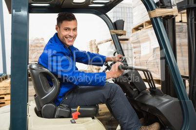 Driver operating forklift machine in warehouse