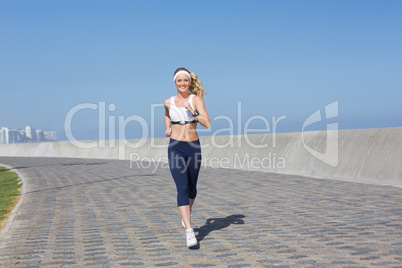 Fit blonde jogging on the pier