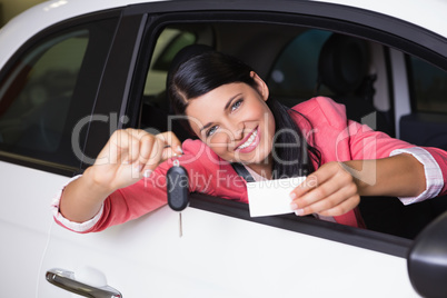 Smiling woman holding car key and business card