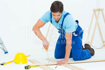 Repairman fixing screw on plank