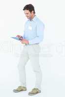 Confident businessman writing on clipboard