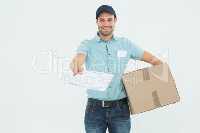 Delivery man with package giving clipboard for signature