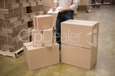 Warehouse worker checking his list on clipboard