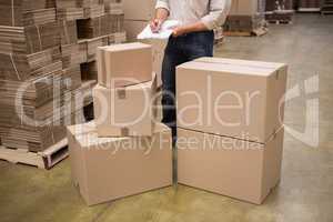 Warehouse worker checking his list on clipboard