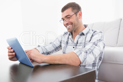 A smiling man using a tablet