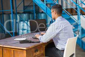 Warehouse manager working on computer