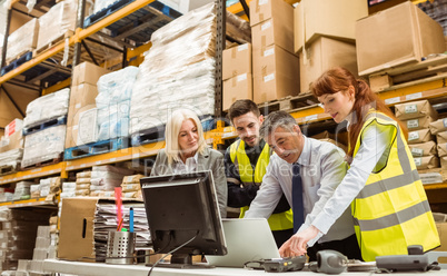 Warehouse managers and worker talking