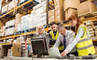 Warehouse managers and worker talking