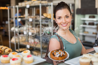 Pretty brunette showing a pastry