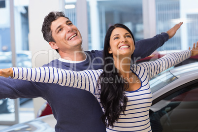 Happy couple standing with arms outstretched