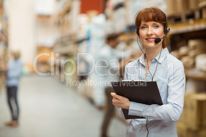 Manager wearing a headset while holding clipboard