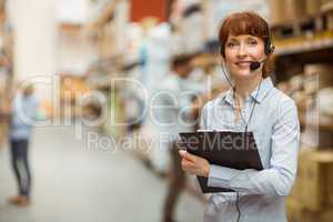 Manager wearing a headset while holding clipboard