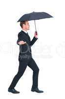 Concentrated businessman with umbrella walking