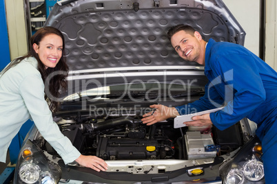 Mechanic smiling at the camera with customer