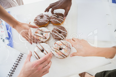 Business people taking doughnut at desk