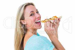 Smiling blonde eating slice of pizza