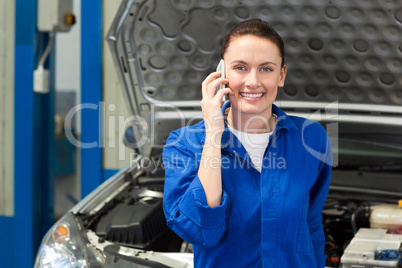 Mechanic smiling at the camera on the phone