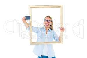 Blonde woman taking a selfie through a frame