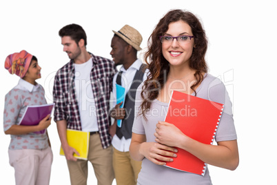 Smiling student standing with friends behind her