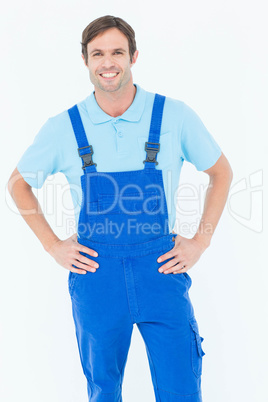 Happy carpenter in overalls with hands on hip