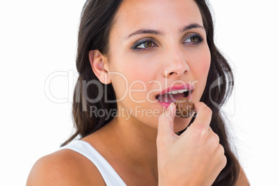 Pretty brunette eating chocolate candy