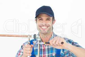 Portrait of happy plumber fixing pipe