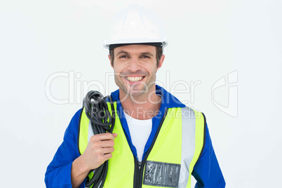 Confident electrician with wire against white background
