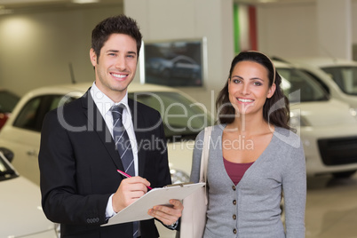 Smiling businessman undersign a car contract