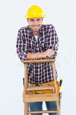 Repairman holding spanner while climbing ladder