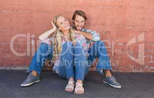 Attractive couple sitting on ground