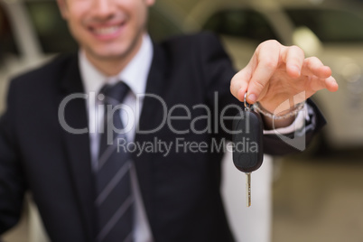 Smiling salesman giving a customer car keys