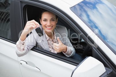 Pretty woman giving thumbs up while holding key