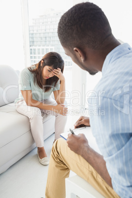 Therapist taking notes on his upset patient