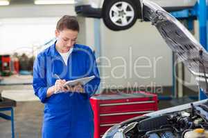 Mechanic examining under hood of car