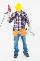 Male repairman holding drill machine and hammer