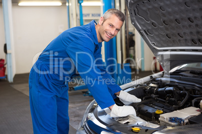 Mechanic examining under hood of car