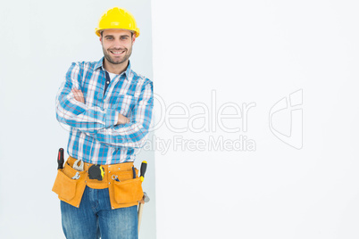 Confident repairman leaning on blank billboard