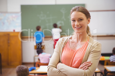 Pretty teacher smiling at camera at back of classroom Pretty teacher smiling at camera at back of classroom