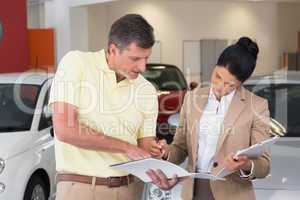Salesperson talking with her customer while holding a booket