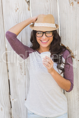 Pretty brunette holding take away coffee