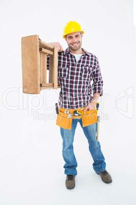 Confident handyman carrying ladder