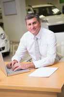 Cheerful businessman typing on laptop